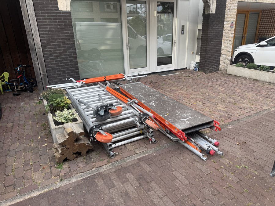 Steigeronderdelen klaargezet bij een voordeur op de begane grond